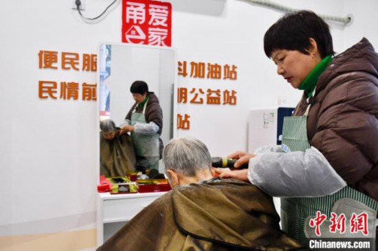 胡玉斐(右一)在當?shù)毓嬲久β?。羅夢圓 攝